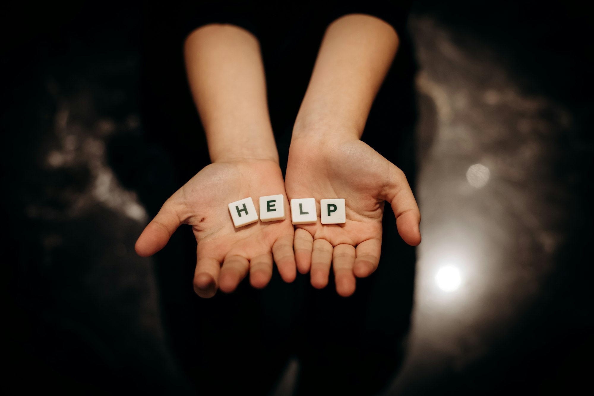 Girl asking for help. Girl stretches out her hands with the word help in the palms