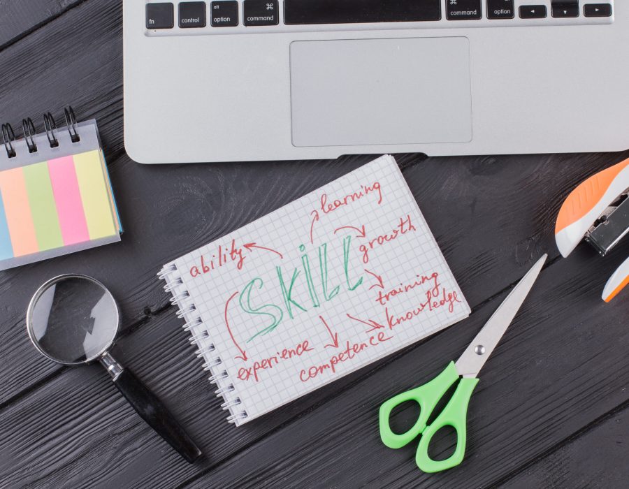 Skills concept and stationery accessories flat lay. Dark wooden table on the background.